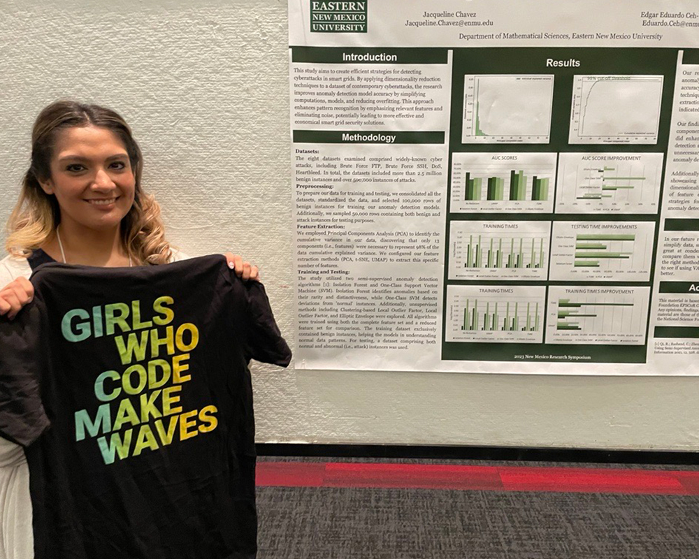 Jacqueline Chavez at conference holding a tshirt with the text GIRLS WHO CODE MAKE WAVES