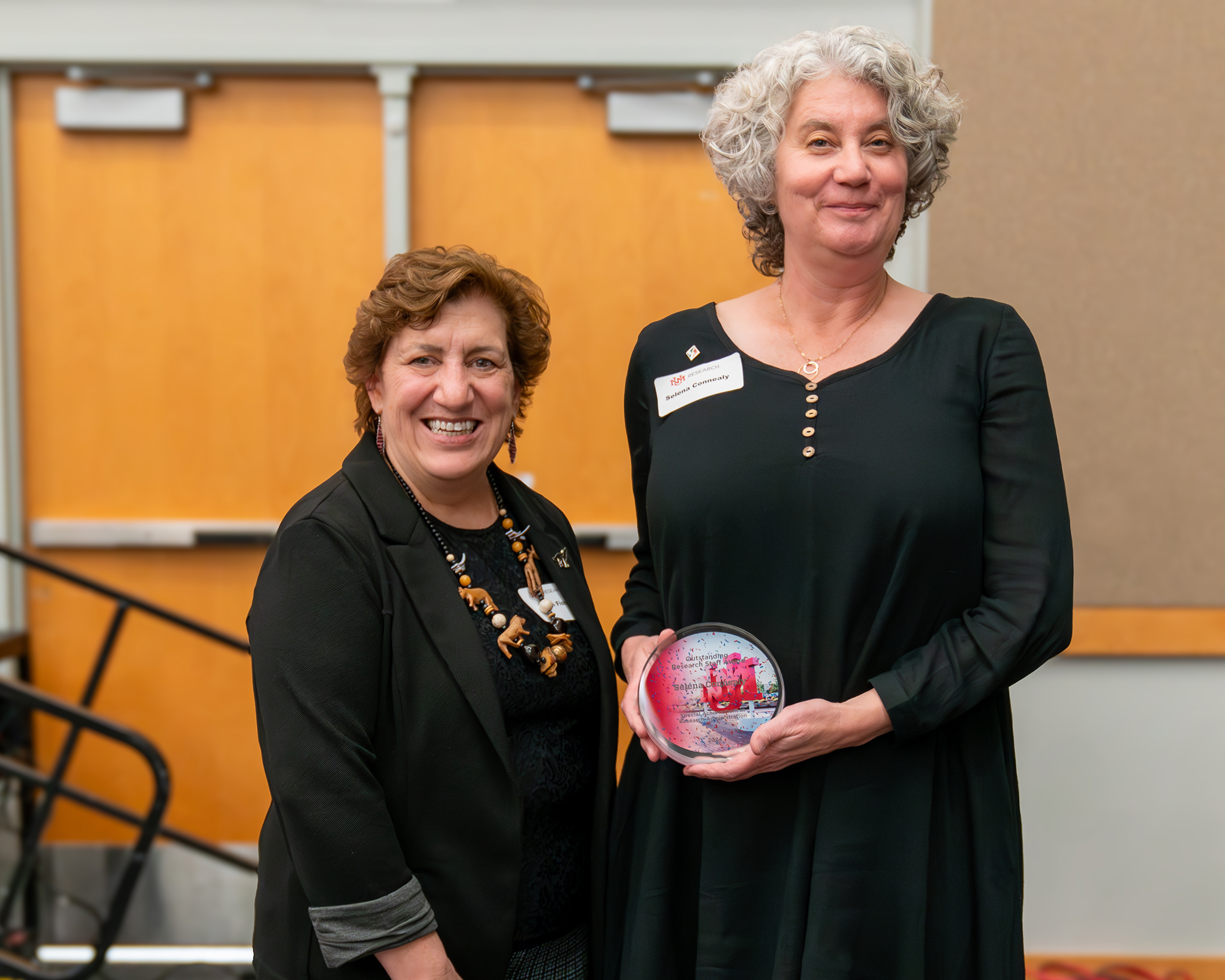 UNM Vice President for Research Ellen Fisher presents Selena Connealy, Associate Director of NM EPSCoR, with an Outstanding Research Staff Award.