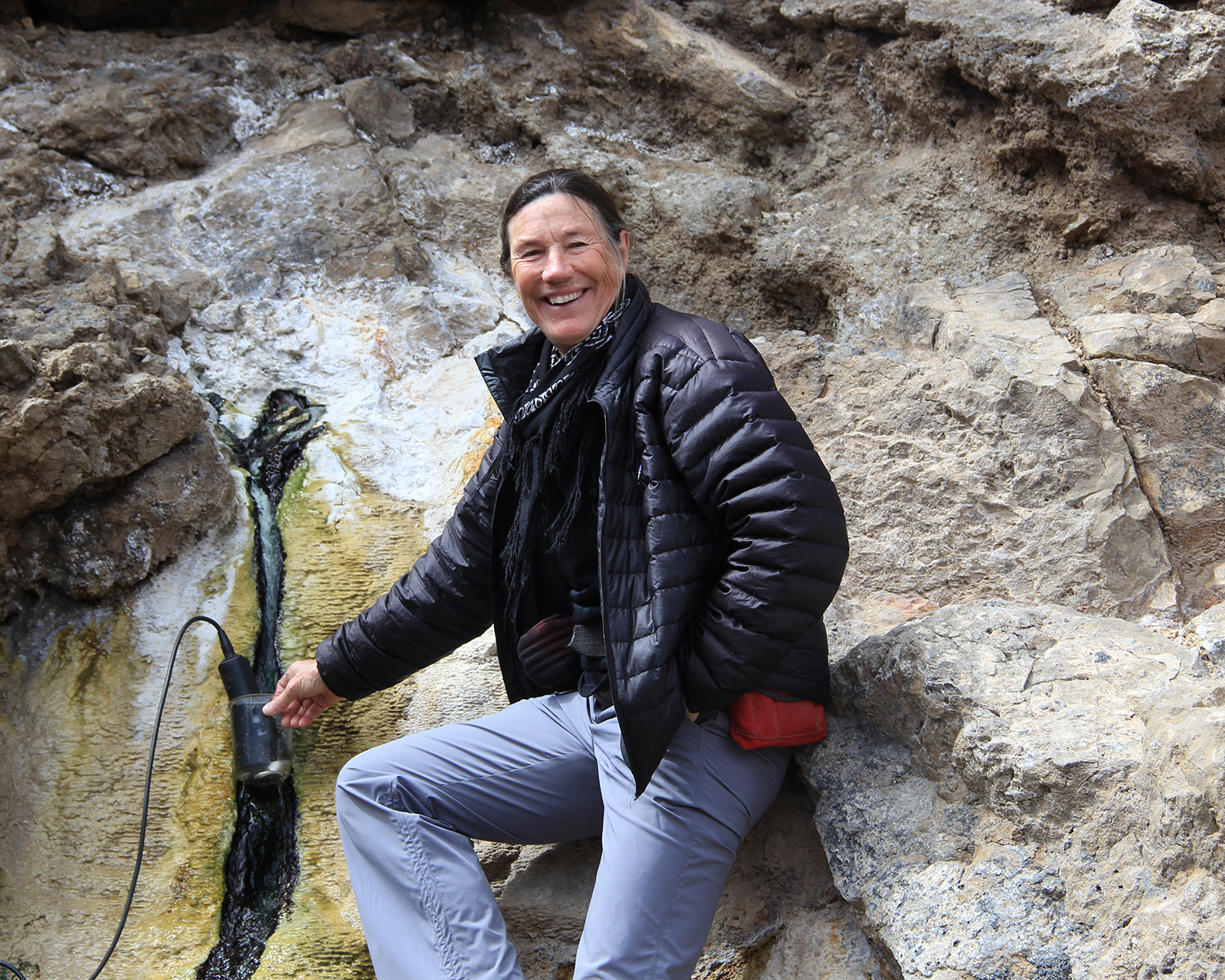 woman posing with scientific equipment at a hot spring