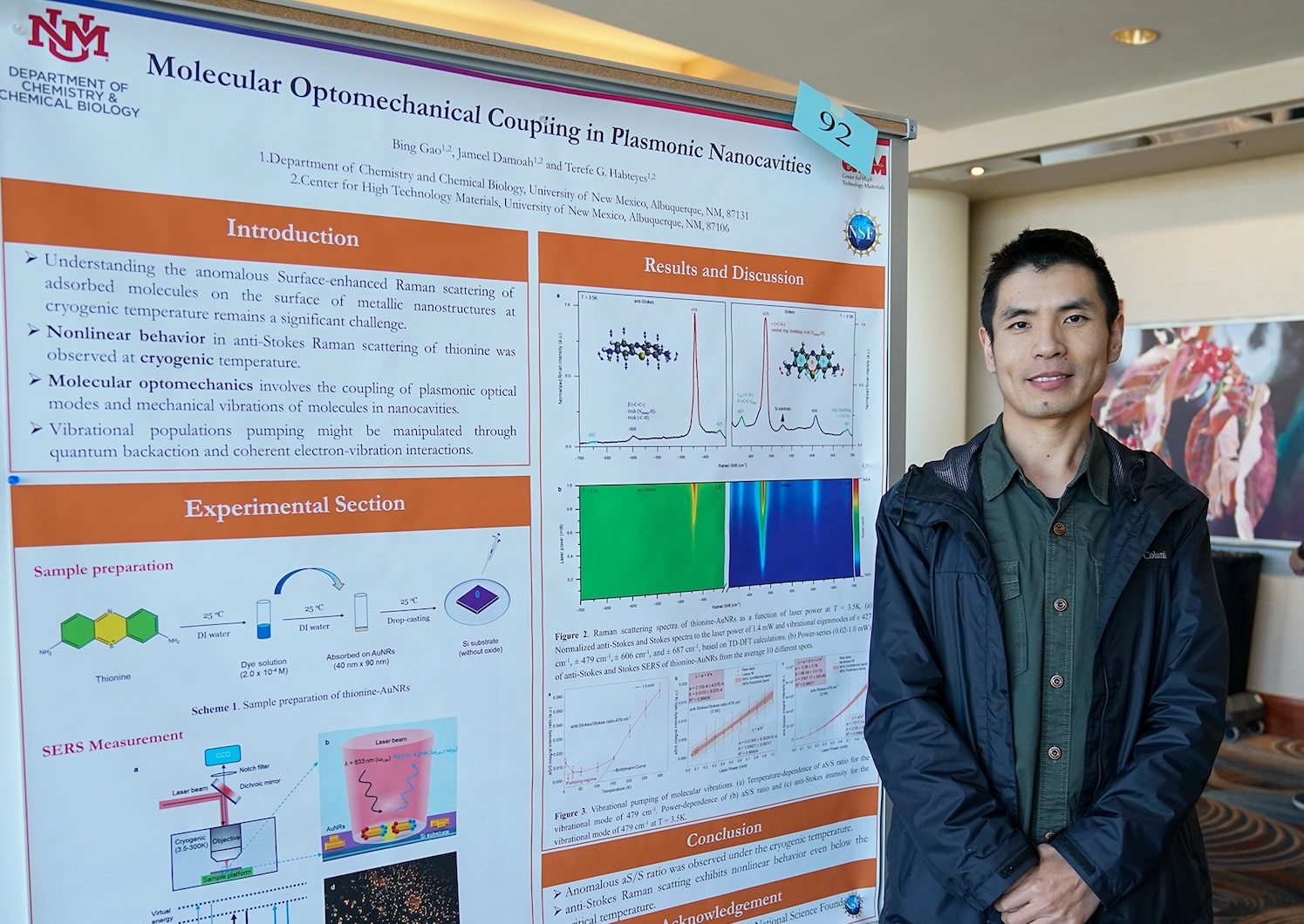 male PhD student in front of poster